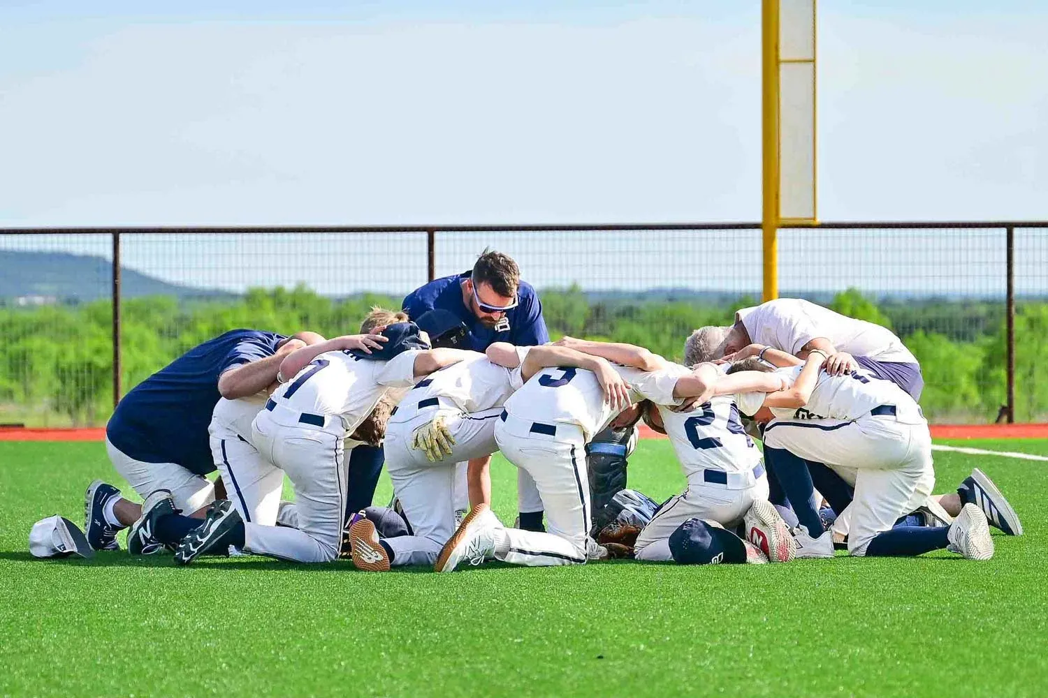A youth baseball team huddled together on the field